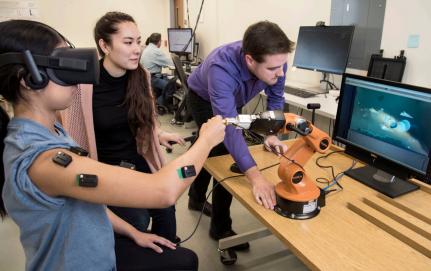 Three people working on a lab computer