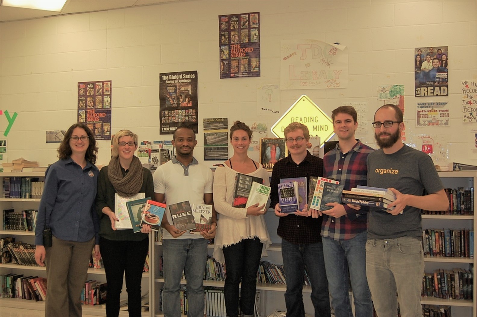 JDC Members posing in front of their library